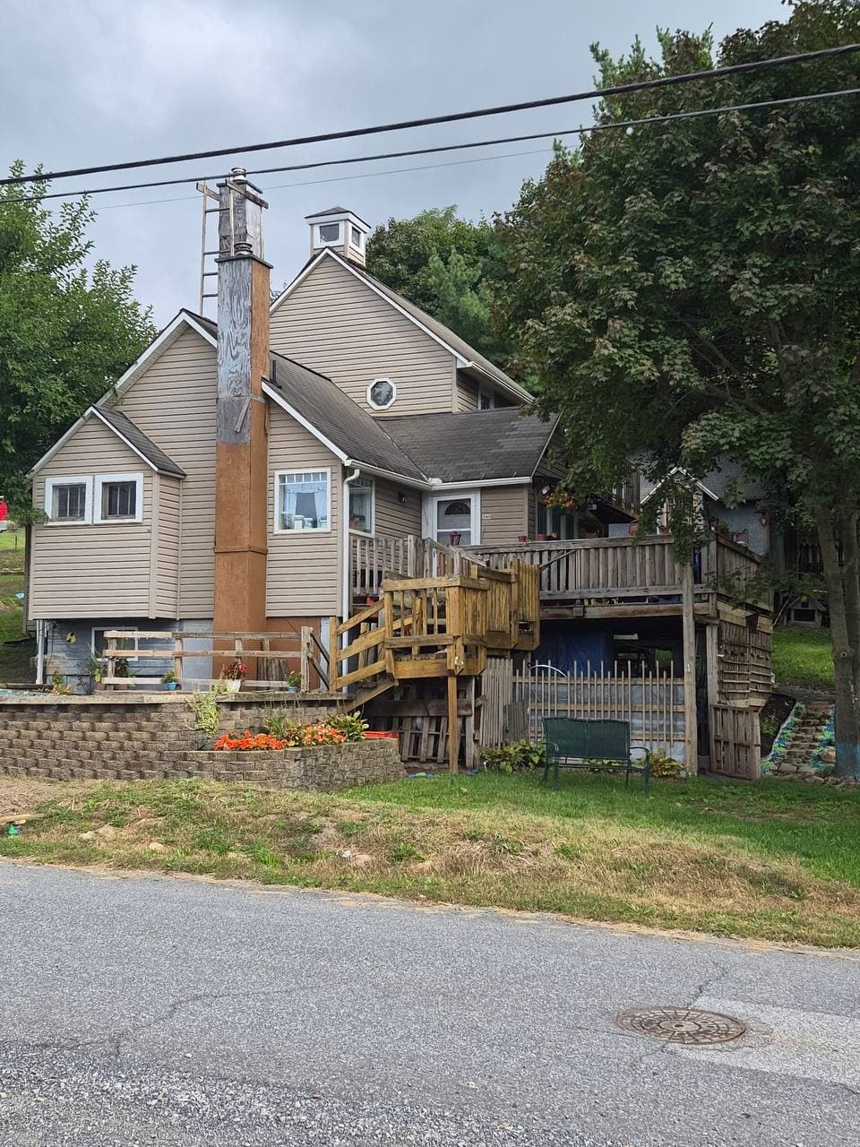 Tan-sided 1929 home with a raised wooden deck at 280 Old State Road, Bedford Township