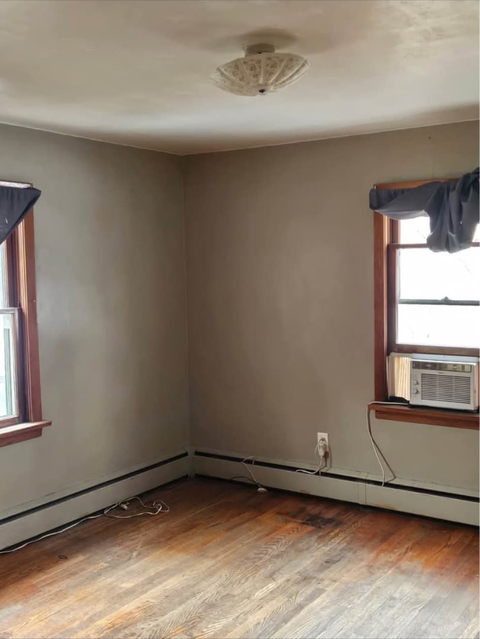 Front-house bedroom with hardwood floors and two windows