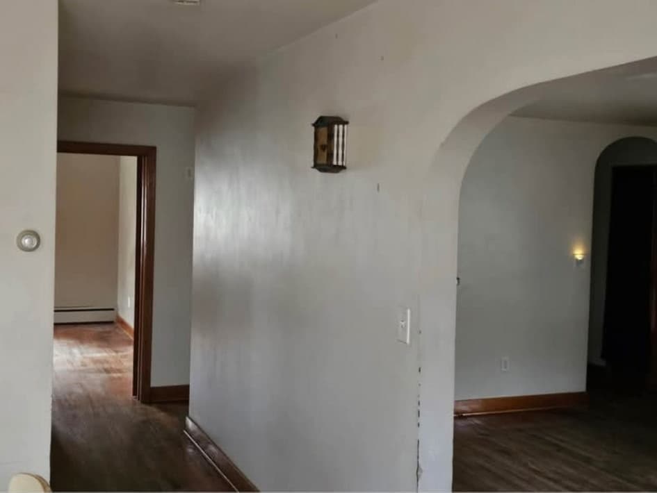 Front-house hallway with arched openings and hardwood floors