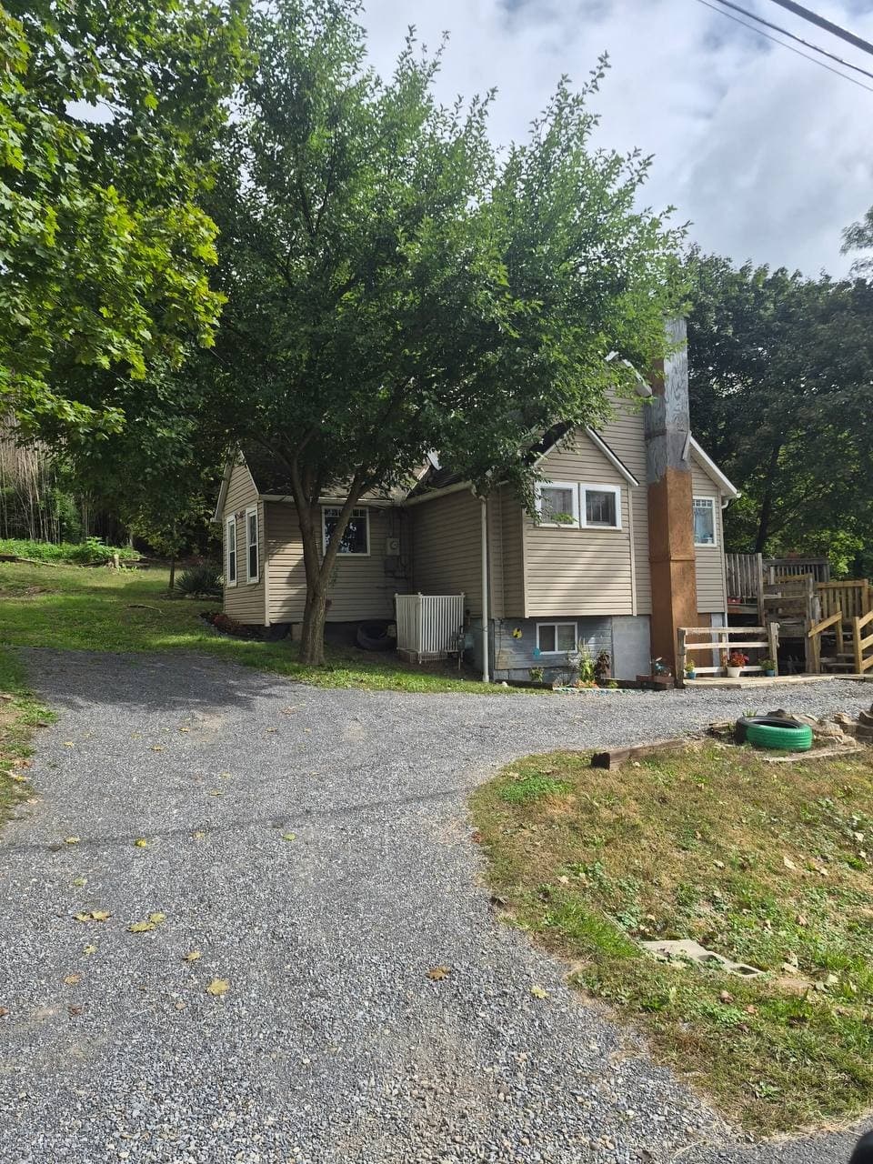 Gravel driveway leading up to the side of 280 Old State Road under a shade tree